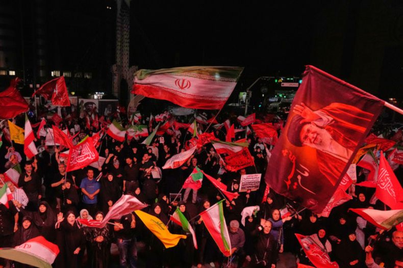 Manifestantes progubernamentales ondean banderas iraníes y religiosas en una concentración en conmemoración del ayatolá Alí Jamenei, el cual aparece en una bandera a la derecha, el sábado 11 de julio de 2026, en una plaza de Teherán. (Foto AP/Vahid Salemi)