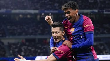 Robert Lewandowski, del Barcelona, celebra después de anotar el segundo gol de su equipo con Lamine Yamal, a la derecha, durante un partido de fútbol de La Liga española entre el Real Madrid y el Barcelona en el estadio Santiago Bernabéu en Madrid, España, el sábado 26 de octubre de 2024. (AP Foto/Manu Fernández)