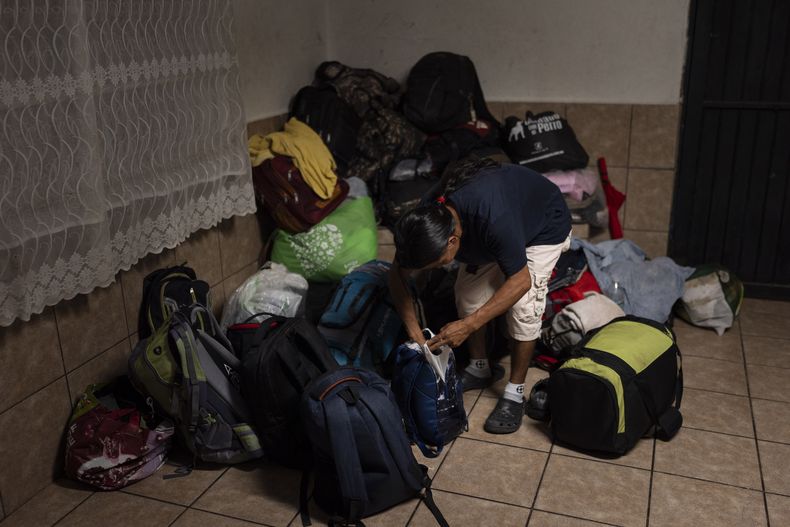 Una persona busca entre sus pertenencias en un montón de bolsas de otros migrantes deportados de vuelta a su país, en una capilla en el refugio para migrantes San Juan Bosco en Nogales, México, el martes 25 de junio de 2024. Los mexicanos suponían el 38% de las personas detenidas en mayo, por debajo del 85% de 2011 pero aún la nacionalidad más frecuente por mucho. (AP Foto/Jae C. Hong)