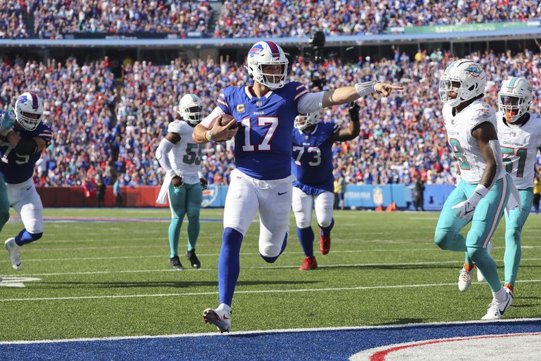 Josh Allen (17), quarterback de los Bills de Buffalo, corre rumbo a la zona de anotación para un touchdown en frente del safety de los Dolphins de Miami, Jevon Holland, durante la segunda mitad del juego de la NFL, el domingo 1 de octubre de 2023, en Orchard Park, Nueva York. (AP Foto/Jeffrey T. Barnes)