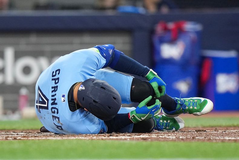 El bateador designado de los Azulejos de Toronto George Springer se deja caer tras ser golpeado en el pie por una bola de foul en el encuentro ante los Mellizo de Minnesota el sábado 11 de abril del 2026. (Nathan Denette/The Canadian Press via AP)