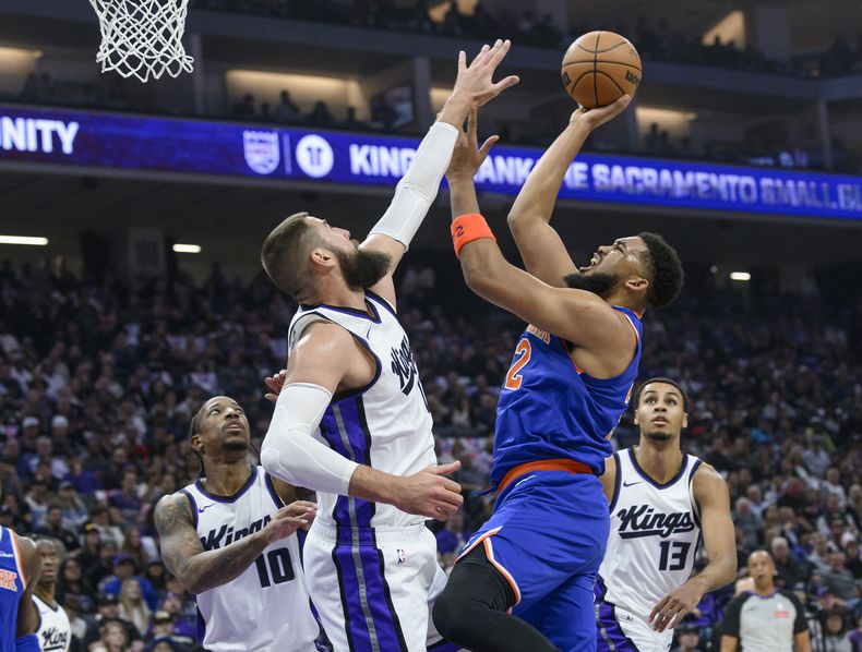 Karl-Anthony Towns (centro a la derecha) de los Knicks de Nueva York dispara al aro sobre Jonas Valanciunas de los Kings de Sacramento, el lunes 10 de marzo de 2025, en Sacramento. (AP Foto/Randall Benton)