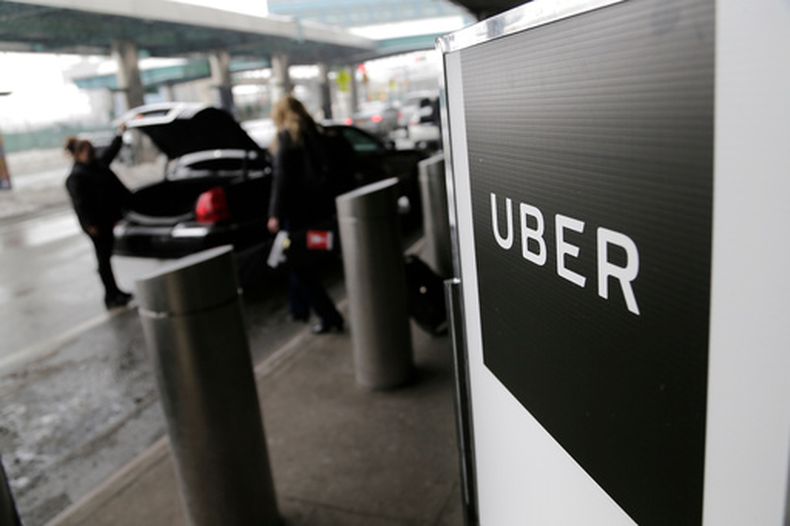 En esta imagen del 15 de marzo de 2017 se puede ver un letrero que marca un punto de encuentro para servicios de Uber en el Aeropuerto LaGuardia de Nueva York. (AP Foto/Seth Wenig, Archivo)