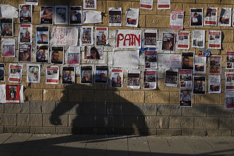 Fotos de israelíes desaparecidos y retenidos en Gaza, pegadas en un muro en Tel Aviv, Israel, el 18 de octubre de 2023. El ejército israelí dice que unas 200 personas fueron secuestradas y llevadas a la Franja tras un ataque transfronterizo de Hamás el 7 de octubre. (AP Foto/Ohad Zwigenberg)