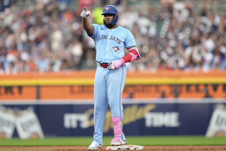 Vladimir Guerrero Jr., de los Azulejos de Toronto, reacciona después de batear un doblete con el que anotó Nathan Lukes durante la quinta entrada del juego de béisbol de Grandes Ligas ante los Tigres de Detroit, el viernes 25 de julio de 2025, en Detroit. (AP Foto/Ryan Sun)
