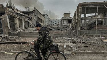 Un hombre circula en bicicleta frente a la oficina de correos destruida por un ataque aéreo ruso en Kurájove, en la región ucraniana de Donetsk, el 7 de noviembre de 2024. (AP Foto/Anton Shtuka)