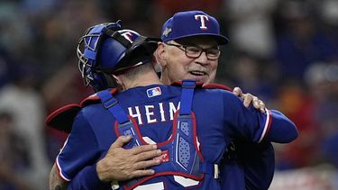 Bruce Bochy, manager de los Rangers de Texas, abraza a Jonah Heim, tras el séptimo juego de la Serie de Campeonato de la Liga Americana ante los Astros de Houston, el lunes 23 de octubre de 2023 (AP Foto/David J. Phillip)