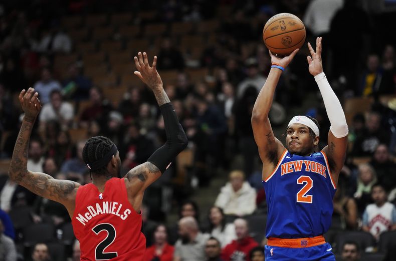 Miles McBride, de los Knicks de Nueva York, dispara frente a Jalen McDaniels, de los Raptors de Toronto, el miércoles 27 de marzo de 2024 (Frank Gunn/The Canadian Press via AP)