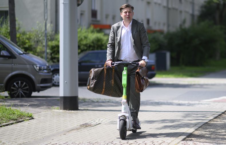 El principal candidato del partido de ultraderecha Alternativa por Alemania al Parlamento Europeo, Maximilian Krah, sale de un centro de votación en una patineta eléctrica tras votar en los comicios europeos y locales en Dresde, Alemania, el domingo 9 de junio de 2024. (Robert Michael/dpa via AP)