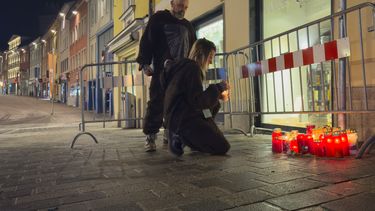 Una persona enciende una vela en el lugar de un apuñalamiento en Villach, Austria, el domingo 16 de febrero de 2025. (AP Foto/Darko Bandic)