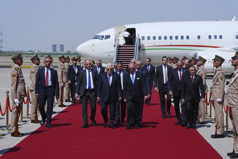 El ministro de Exteriores de Irak, Fuad Hussein (centro, derecha), recibe al presidente palestino, Mahmoud Abbas, a su llegada al Aeropuerto Internacional de Bagdad antes de la 34ta cumbre de la Liga Árabe, en Bagdad, Irak, el 16 de mayo de 2025. (Murtadha Al-Sudani/Pool Foto vía AP)