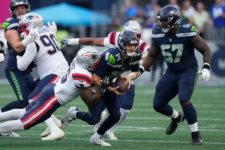 Sam Darnold, quarterback de los Seahawks de Seattle, es capturado por Dremont Jones, quarterback de los Patriots de Nueva Inglaterra, en el partido del miércoles 9 de septiembre de 2026 (AP Foto/Stephen Brashear)