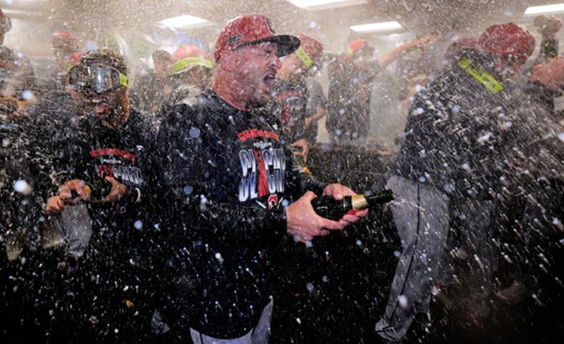 Stephen Vogt, manager de los Guardianes de Cleveland, arroja champaña durante la celebración tras clasificarse a los playoffs, el jueves 24 de septiembre de 2026 (AP Foto/Charles Krupa)