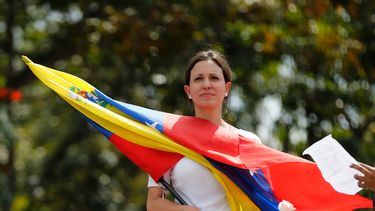 americateve | En esta fotograf&iacute;a del 26 de febrero de 2014, la l&iacute;der de oposici&oacute;n y congresista Mar&iacute;a Corina Machado sostiene una bandera venezolana durante una protesta de mujeres afuera de los cuarteles de la Guardia Nacional Bolivariana e