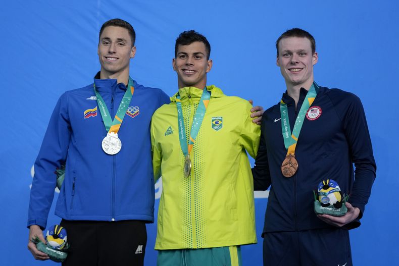 Desde la izquierda, el venezolano Alfonso Mestre, el brasileño Guilherme Costa y el estadounidense James Plage posan con sus medallas en el podio de los 400 metros libre de los Juegos Panamericanos en Santiago, Chile, el sábado 21 de octubre de 2023. (AP Foto/Fernando Vergara)