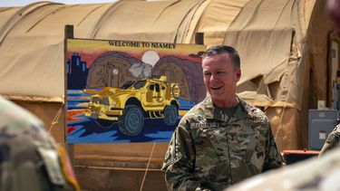 En esta imagen de la Fuerza Aérea de Estados Unidos, el general de división Kenneth P. Ekman habla delante de un cartel de Bienvenido a Niamey que muestra vehículos militares de Estados Unidos en la base aérea 101 en Níger, el 30 de mayo de 2024. (Sargento técnico Christopher Dyer, Fuerza Aérea de Estados Unidos vía AP)