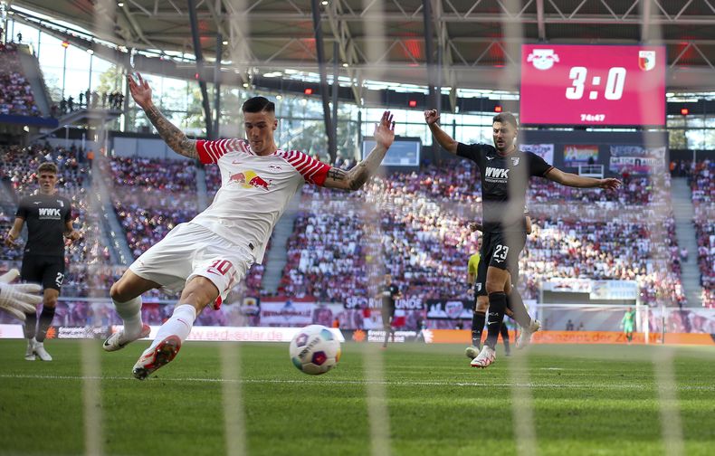 Benjamin Sesko del Leipzig trata de rematar a gol en el partido contra Augsburgo en la Bundesliga, el sábado 16 de septiembre de 2023, en Leipzig. (Jan Woitas/dpa vía AP)
