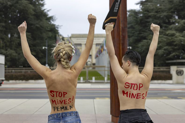 Activistas del grupo feminista FEMEN protestan en apoyo a Ucrania y para exigir la expulsión de Rusia de Naciones Unidas, en el monumento conocido como Silla Rota en la Plaza de las Naciones ubicada frente a la sede europea de la ONU, en Ginebra, Suiza, el viernes 13 de diciembre de 2024. (Salvatore Di Nolfi/Keystone via AP)