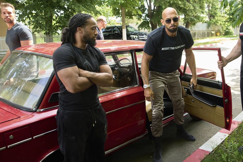 Andrew Tate y su hermano Tristan, arriba, izquierda, llegan a una estación de policía en un vehículo Lada en Voluntari, Rumania, el miércoles 21 de mayo de 2025. (AP Foto/Vadim Ghirda)