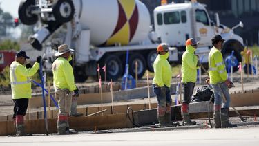 ARCHIVO – Miembros de un equipo de construcción esperan para verter concreto en un estacionamiento, el 4 de septiembre de 2024, en Waukee, Iowa. (AP Foto/Charlie Neibergall, Archivo)