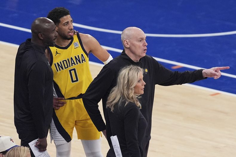 El entrenador en jefe de los Pacers de Indiana, Rick Carlisle (derecha), da indicaciones a los jugadores en la cancha mientras el entrenador asistente Lloyd Pierce (extrema izquierda) conversa con el base Tyrese Haliburton (0) durante el tercer cuarto del Juego 5 de las finales de la Conferencia Este de la NBA contra los Knicks de Nueva York, el jueves 29 de mayo de 2025, en Nueva York. (Foto AP/Frank Franklin II)