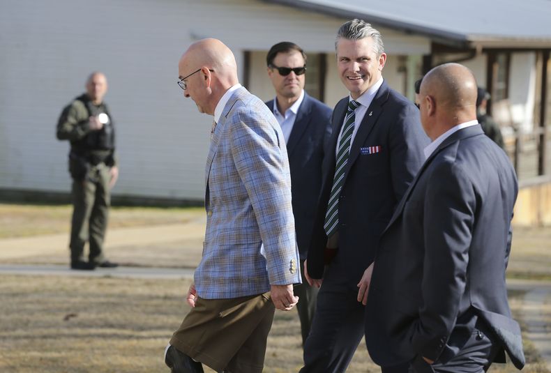 El secretario de Defensa de Estados Unidos, Pete Hegseth, en el centro, camina con Scott Burns, a la izquierda, mientras entran en la recaudación de fondos A Southern Salute to the Troops, organizada por la organización sin ánimo de lucro 7 Days for the Troops, el jueves 20 de marzo de 2025, en Tupelo, Mississippi. (Thomas Wells /The Northeast Mississippi Daily Journal via AP)