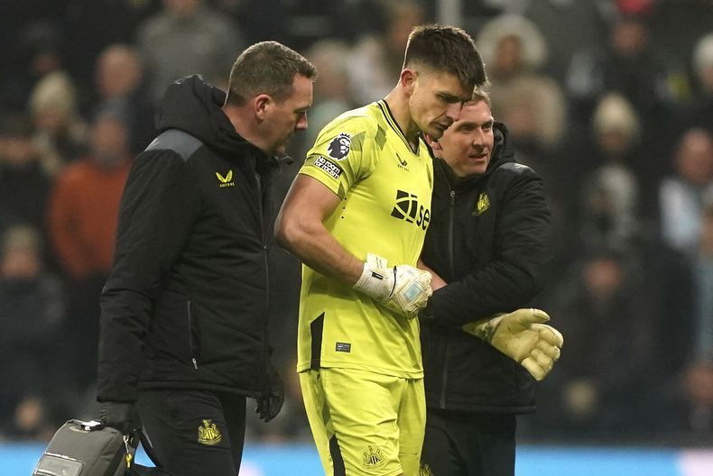 El arquero de Newcastle Nick Pope (centro) sale de la cancha tras sufrir una lesión en el partido contra Manchester United en la Liga Premier, el sábado 2 de diciembre de 2023, en Newcastle. (Owen Humphreys/PA vía AP)
