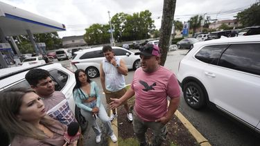 ARCHIVO - Henry Carmona, derecha, que huyó de Venezuela tras recibir amenazas de muerte por negarse a participar en marchas a favor del gobierno de Nicolás Maduro, conversa con amigos tras una conferencia de prensa en que líderes de la comunidad venezolana denunciaron cambios a las normas de protección para cientos de miles de venezolanos, incluyendo a Carmona, de la deportación, el lunes 3 de febrero de 2025, en Doral, Florida. (AP Foto/Rebecca Blackwell, archivo)