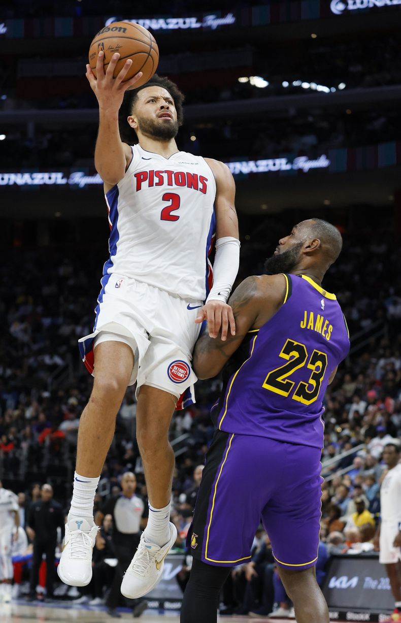 Cade Cunningham (2), de los Pistons de Detroit, se alza para buscar un enceste mientras LeBron James (23), de los Lakers de Los Ángeles, lo marca durante la segunda mitad del juego de baloncesto de la NBA, el lunes 4 de noviembre de 2024, en Detroit. (AP Foto/Duane Burleson)