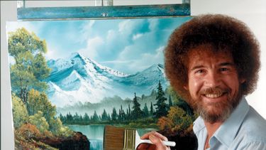 En esta imagen difundida por Bob Ross Inc., Bob Ross posa para una fotografía frente a una de sus obras. (Bob Ross Inc. vía AP)