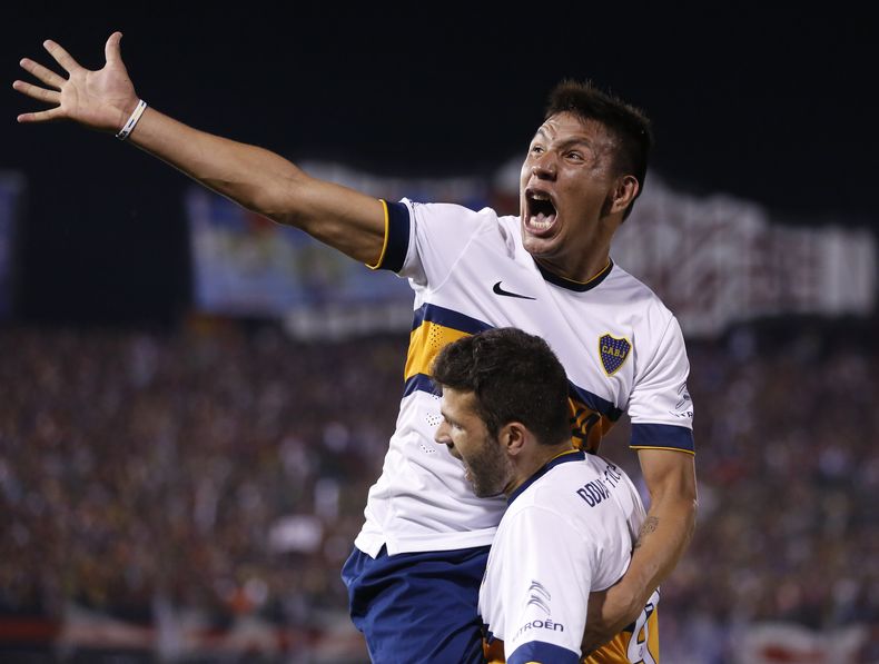 Emmanuel Gigliotti carga a su compa&ntilde;ero del Boca Juniors, Andr&eacute;s Eliseo Ch&aacute;vez, durante el festejo de un gol contra el Cerro Porte&ntilde;o de Paraguay, en los cuartos de final de la Copa Sudamericana, el jueves 6 de noviembre de 2014