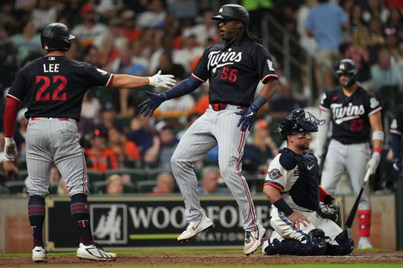 Josh Bell (56), bateador designado de los Mellizos de Minnesota, celebra con Brooks Lee (22) después de batear un cuadrangular mientras el receptor Christian Vázquez, derecha, de los Astros de Houston, observa durante la sexta entrada del juego de béisbol de Grandes Ligas, el lunes 29 de junio de 2026, en Houston. (AP Foto/Jon Shapley)