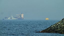 Una patrullera emiratí (izquieda), navega cerca de un petrolero fondeado en el golfo de Omán, cerca del estrecho de Ormuz, vistos desde una carretera costera cerca de Khor Fakkan, Emiratos Árabes Unidos, el 1 de mayo de 2026. (AP Foto/Fatima Shbair)