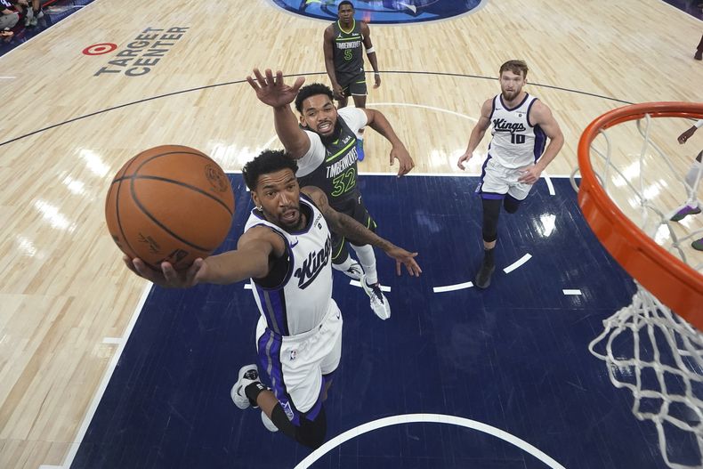 Malik Monk, base de los Kings de Sacramento, dispara frente a Karl-Anthony Towns, de los Timberwolves de Minne3sota, el viernes 1 de marzo de 2024 (AP Foto/Abbie Parr)
