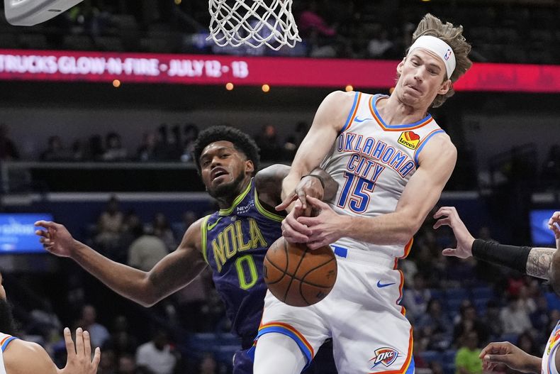 El pívot del Thunder de Oklahoma City, Branden Carlson (15), lucha debajo de la canasta con el alero de los Pelicans de Nueva Orleans, Keion Brooks Jr. (0), en la primera mitad de un partido de baloncesto de la NBA en Nueva Orleans, el domingo 13 de abril de 2025. (AP Foto/Gerald Herbert)