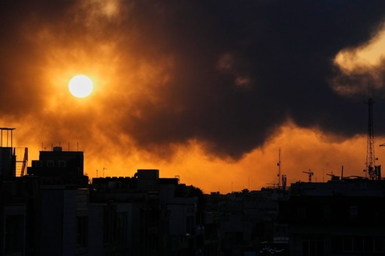 El sol se oculta tras una columna de humo provocada por el ataque de Estados Unidos e Israel en Teherán, Irán, el martes 3 de marzo de 2026. (AP Foto/Vahid Salemi)