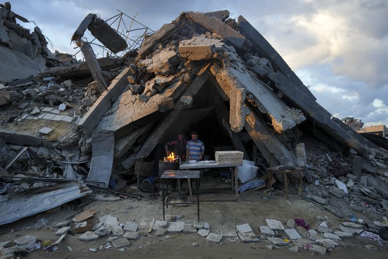 Un hombre vende pan bajo los restos de su panadería, destruida por una ofensiva aérea y terrestre israelí en Jabaliya Franja de Gaza, el miércoles 5 de febrero de 2025. (AP Foto/Abdel Kareem Hana)