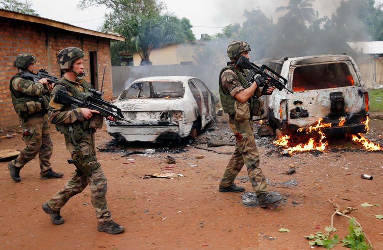 Soldados franceses pasan junto a dos veh&iacute;culos de la Seleka, una alianza de grupos rebeldes en su mayor&iacute;a musulmanes, incendiados por turbas cristianas en Bangui, capital de la Rep&uacute;blica Centroafricana, el lunes 9 de diciembre de 2013