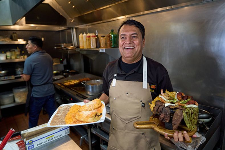 El cocinero y propietario de un restaurante mexicano Marco Mendoza prepara molcajete, un plato tradicional mexicano, en Cuernavacas Grill, en el centro de Los Ángeles, el martes 28 de abril de 2026. (AP Foto/Damian Dovarganes)