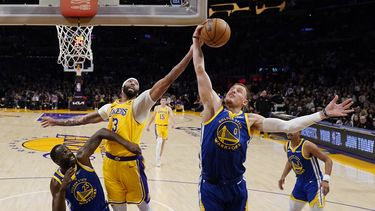 El alero de los Lakers de Los Ángeles Anthony Davis va por el rebote frente a Donte DiVincenzo y Draymond Green de los Warriors de Golden State en el juego 6 de la serie de semifinales de la Conferencia Oeste el viernes 12 de mayo del 2023. (AP Foto/Ashley Landis)