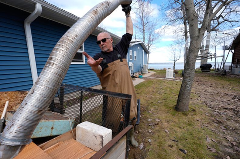 Tom Peterman limpia los destrozos del exterior de su casa tras las recientes inundaciones en Black Lake, el miércoles 29 de abril de 2026, en Grant Township, Michigan. (Foto AP/Paul Sancya)