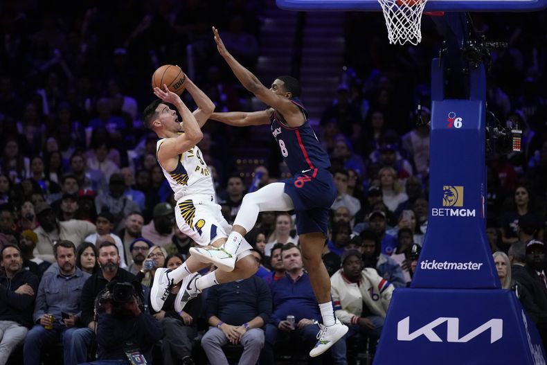 T.J. McConnell, de los Pacers de Indiana, recibe una falta de DeAnthony Melton, de los 76ers de Filadelfia, en un duelo del torneo In-Season, disputado el martes 14 de noviembre de 2023 (AP Foto/Matt Slocum)