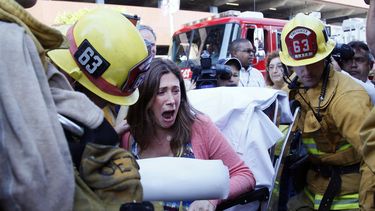 americateve | Avi Abril, que vive en un edificio alto de apartamentos que se incendi&oacute; es llevada a una ambulancia en Los Angeles, el viernes 18 de octubre de 2013. Ocho personas, incluido un ni&ntilde;o y tres bomberos, fueron hospitalizados debido al fuego, que