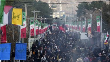 Una multitud de gente camina por una calle en dirección a la tumba del general Qassem Soleimani, general de la Guardia Revolucionaria de Irán, con una mezquita de fondo, en la ciudad de Kermán, a unos 820 kms (510 millas) al sureste de la capital, Teherán, el 4 de enero de 2024. (AP Foto/Vahid Salemi)
