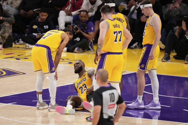 LeBron James (23), de los Lakers de Los Ángeles, yace en la duela después de sufrir una lesión en la rodilla durante la segunda mitad del quinto juego de baloncesto de la NBA en la primera ronda de playoffs frente a los Timberwolves de Minnesota, el miércoles 30 de abril de 2025, en Los Ángeles. (AP Foto/Mark J. Terrill)