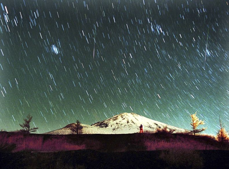 ARCHIVO - La lluvia de meteoritos Leónidas es vista en el cielo sobre el nevado Monte Fuji, la montaña más elevada de Japón, en esta imagen de 7 minutos tomada el 19 de noviembre de 2001. (AP Foto/Itsuo Inouye, archivo)