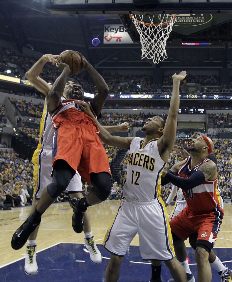 Martell Webster de los Wizards de Washinton intenta tirar a la canasta frente Luis Scola y Evan Turner (12) de los Pacers de Indiana en los playoffs de la NBA el martes 13 de mayo de 2014. (AP Foto/Darron Cummings)