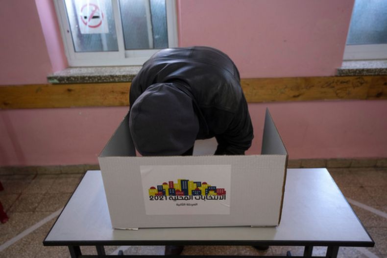 ARCHIVO - Un votante prepara su papeleta en un colegio electoral durante las elecciones municipales de la ciudad de Ramala en Cisjordania, el 26 de marzo de 2022. (Foto AP/Nasser Nasser, Archivo)