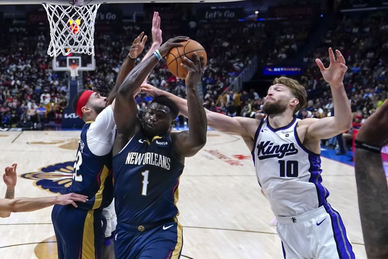 Zion Williamson, de los Pelicans de Nueva Orleáns, salta hacia la canasta frente a Domantas Sabonis, de los Kings de Sacramento, en el encuentro del miércoles 22 de noviembre de 2023 (AP Foto/Gerald Herbert)