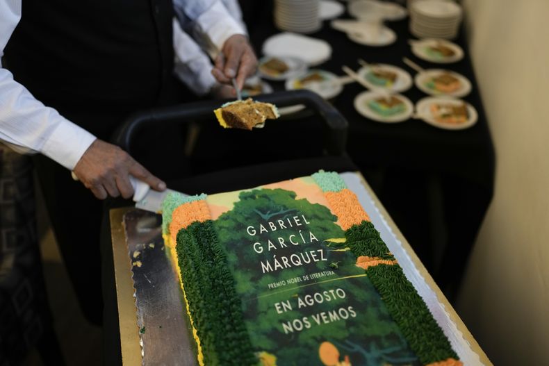 Un mesero corta trozos de un pastel decorado con la portada de la novela En agosto nos vemos para celebrar el cumpleaños del autor colombiano Gabriel García Márquez y el lanzamiento de su novela póstuma en una librería en la Ciudad de México el miércoles 6 de marzo de 2024. (Foto AP/Eduardo Verdugo)